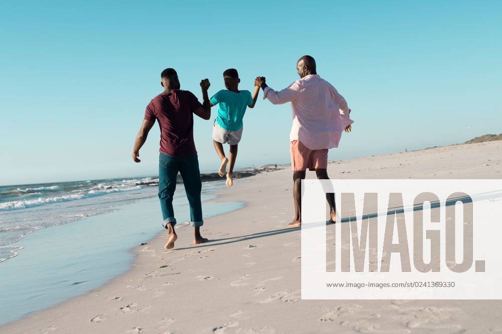 Rear view of african american father and grandfather holding boy s hands and picking him up at beach Rear view of african american father and grandfather holding boy s hands and picking him up at beach. Copy space, unaltered, multigeneration family, together, child, nature, vacation, enjoy, summer., model released, , property released, Cape Town, South Africa, 19.01.2023, 3991088.jpg, people,rear view,african american,father,grandfather,holding,boy,hand,picking,beach,copy space,unaltered,multigeneration,family,together,child,nature,vacation,sea,summer,ocean,water,travel,coast,mother,beautiful,outdoor,happy,holiday,parent,lifestyle,landscape,young,sand,daughter,son,fun,rear,view,african,american,copy,space Senior,Elderly,Man,Male,Black,Mid