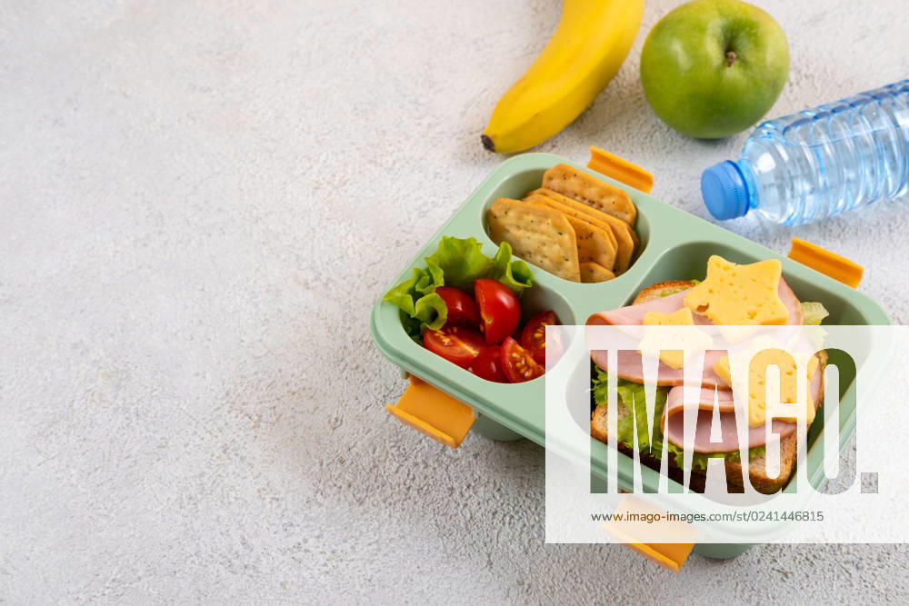 Healthy school lunch box with sandwich and salad on the table. Banana, apple and a bottle of water. Back to school Healthy school lunch box with sandwich and salad on the table. Banana, apple and a bottle of water. Back to school