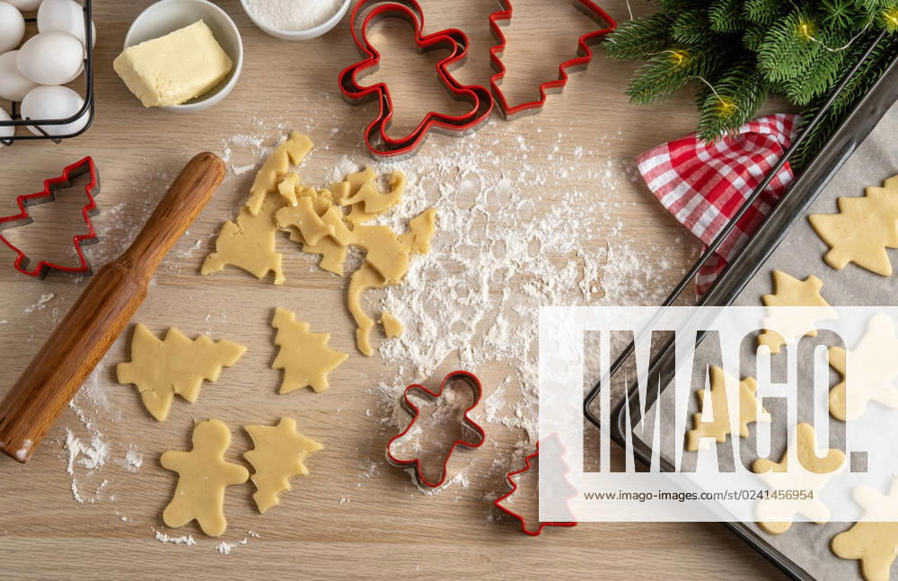Making Christmas Cookies with traditional gingerbread cookies ingredients. Christmas Gingerbread man and fir trees on pan. Top view. Making Christmas Cookies with traditional gingerbread cookies ingredients. Christmas Gingerbread man and fir trees on pan. Top view.