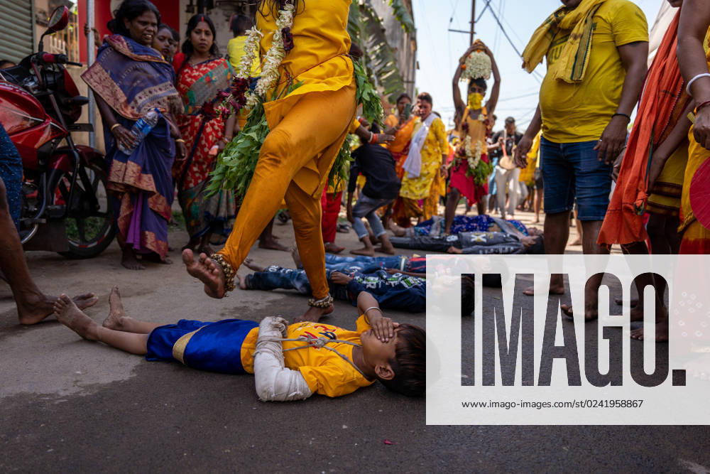 India: Devotees have taken part in a rally ahead of Vel festival Bandel, India, Mrch 6 2023: A little boy with a fracture in his hand, covers his eyes as he is frightened of being stampede by a devotee s leg as it is a ritual of Vel festival celebrated every year by the people of South Indian community of West Bengal, India to celebrate the victory of Hindu god of war Murugan. Bandel West Bengal India