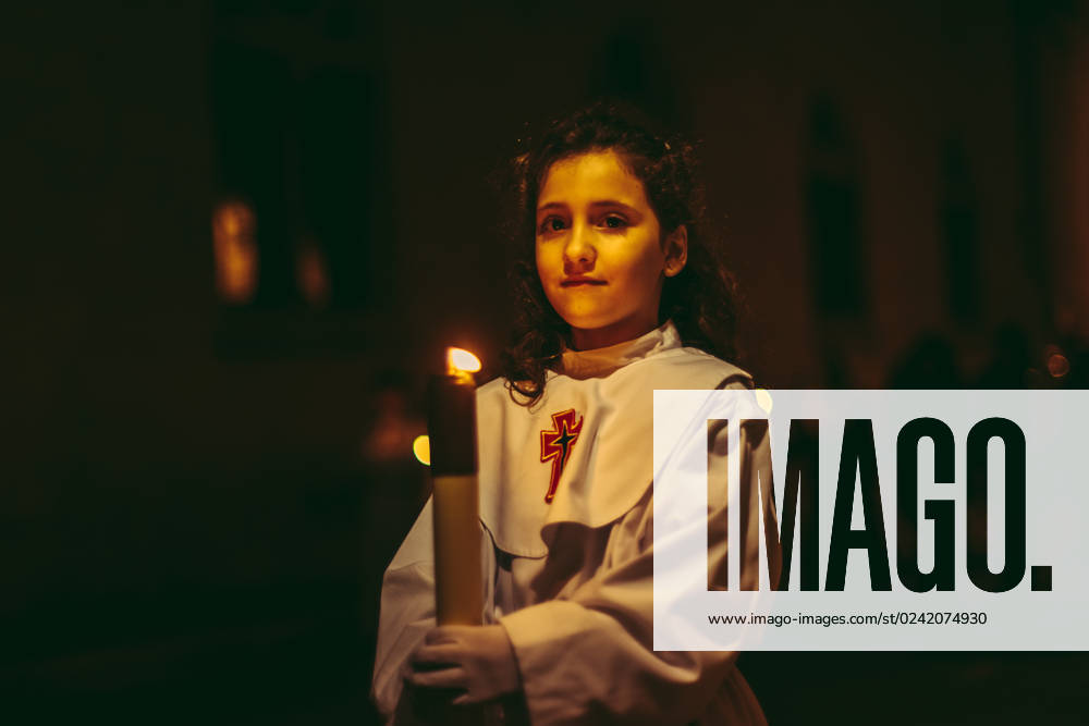 A young girl of the Brotherhood of Germandat Del Sant Ecce Homo takes part with her candle in the Good Friday procession in Tarragona. Tarragona Spain - ZUMAo105 20230407_zap_o105_041