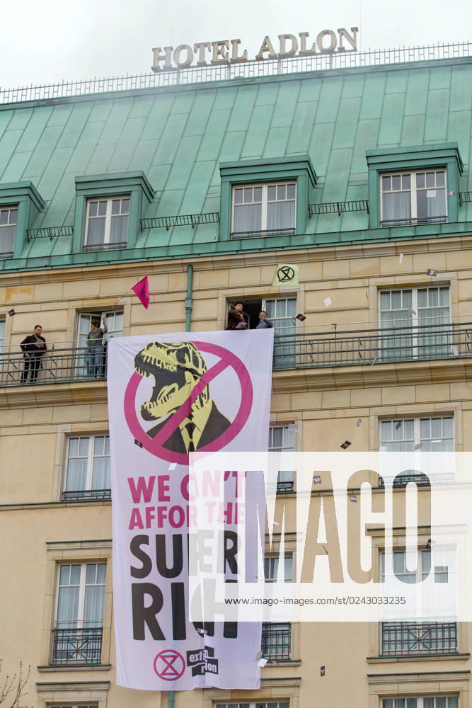 Berlin, Germany, DEU Extinction Rebellion, climate activists hijack Hotel Adlon 13.04.23, Berlin, Germany, DEU Extinction Rebellion, climate activists hijack Hotel Adlon Demonstrators add smoke candles and unfurl a banner on the balcony of one of the upper floors that reads We cant afford the super rich Berlin Berlin Germany