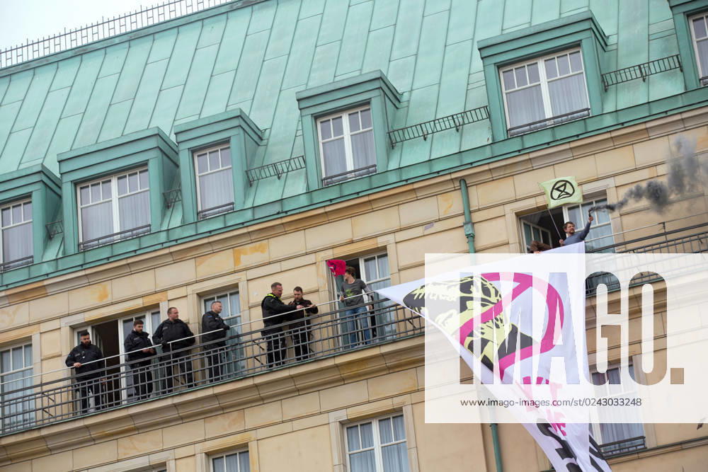 Berlin, Germany, DEU Extinction Rebellion, climate activists hijack Hotel Adlon 13.04.23, Berlin, Germany, DEU Extinction Rebellion, climate activists hijack Hotel Adlon Protesters add smoke candles and unfurl a banner on the balcony of one of the upper floors that reads We cant afford the super rich Police officer