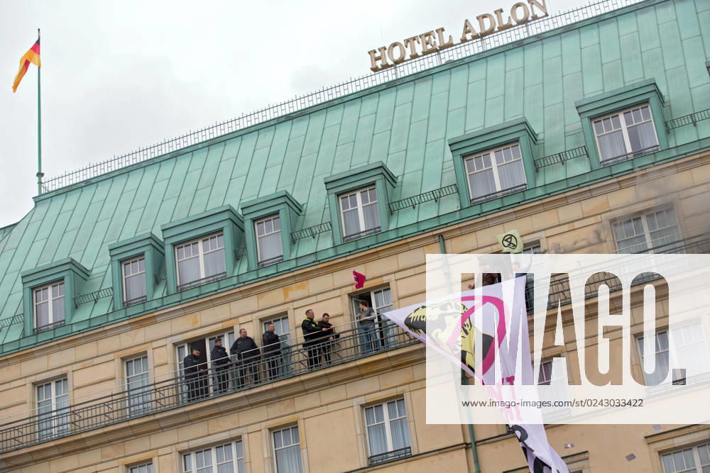 Berlin, Germany, DEU Extinction Rebellion, climate activists hijack Hotel Adlon 13.04.23, Berlin, Germany, DEU Extinction Rebellion, climate activists hijack Hotel Adlon Protesters add smoke candles and unfurl a banner on the balcony of one of the upper floors that reads We cant afford the super rich Police officer