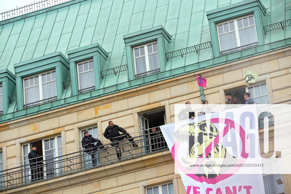 Berlin, Germany, DEU Extinction Rebellion, climate activists hijack Hotel Adlon 13.04.23, Berlin, Germany, DEU Extinction Rebellion, climate activists hijack Hotel Adlon Protesters add smoke candles and unfurl a banner on the balcony of one of the upper floors that reads We cant afford the super rich Police officer