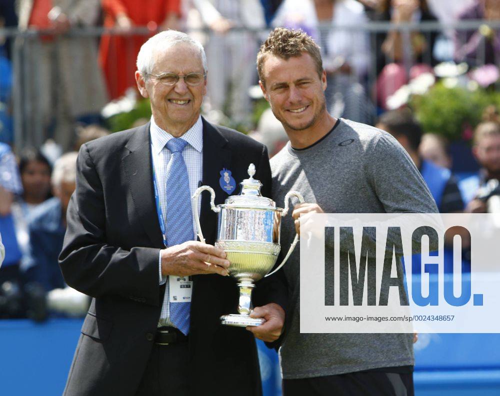 Queens Club, London, England. Aegon Queens Tennis Championships Day Five. The tournament celebrated its four time champions on Centre Court this afternoon with presentations of quarter sized trophies to four-time champions Boris Becker, John McEnroe, Roy Emerson and Lleyton Hewitt. Aussies Roy Emerson and Lleyton Hewitt show off a replica trophy. Martinx ActionPlus11750643