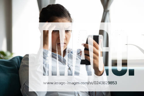 Indignant unhappy Indian young woman looking at smartphone screen, upset sad young girl worried by bad news reading in message, having problem with broken or discharged mobile device - ZUMAla2_ 20230416_zaa_la2_004