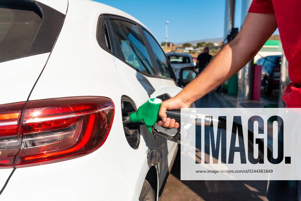 Man with the Pistol refuel Petrol Or Diesel fuel in a white Car Concept from Transportation, Energy crisis, Oil crisis full Tank in the Middle a Price crisis to the Petrol pump