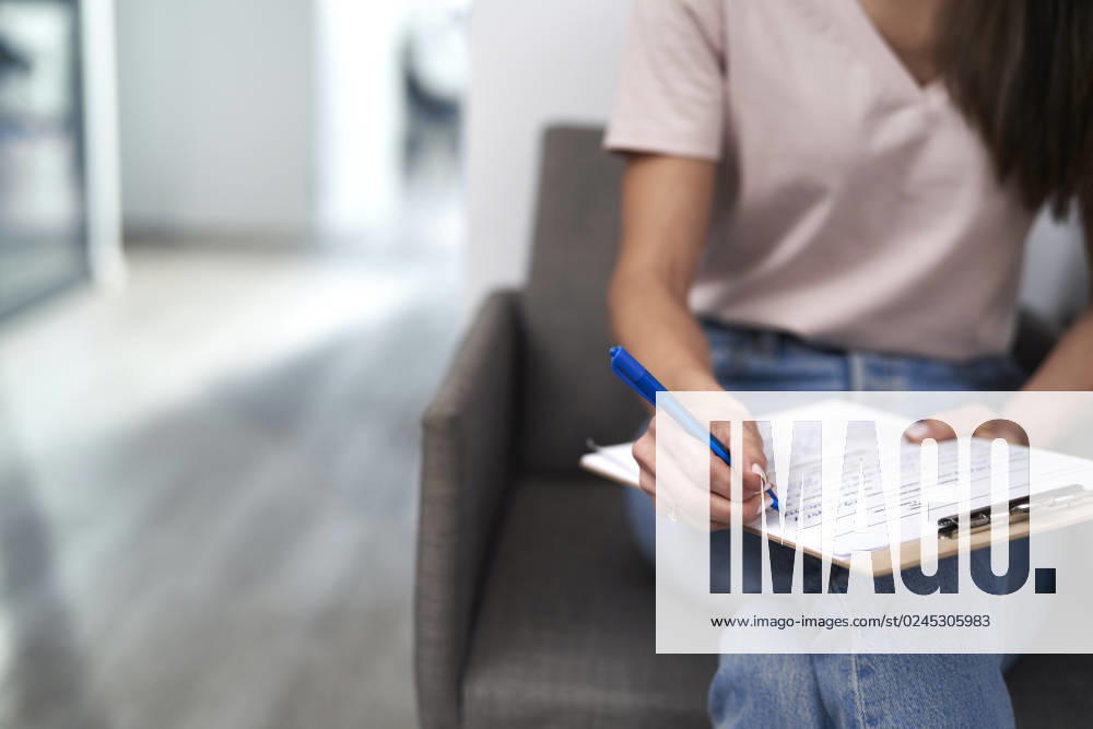 Woman with pen filling form sitting in waiting room model released, Symbolfoto property released, ABIF01843