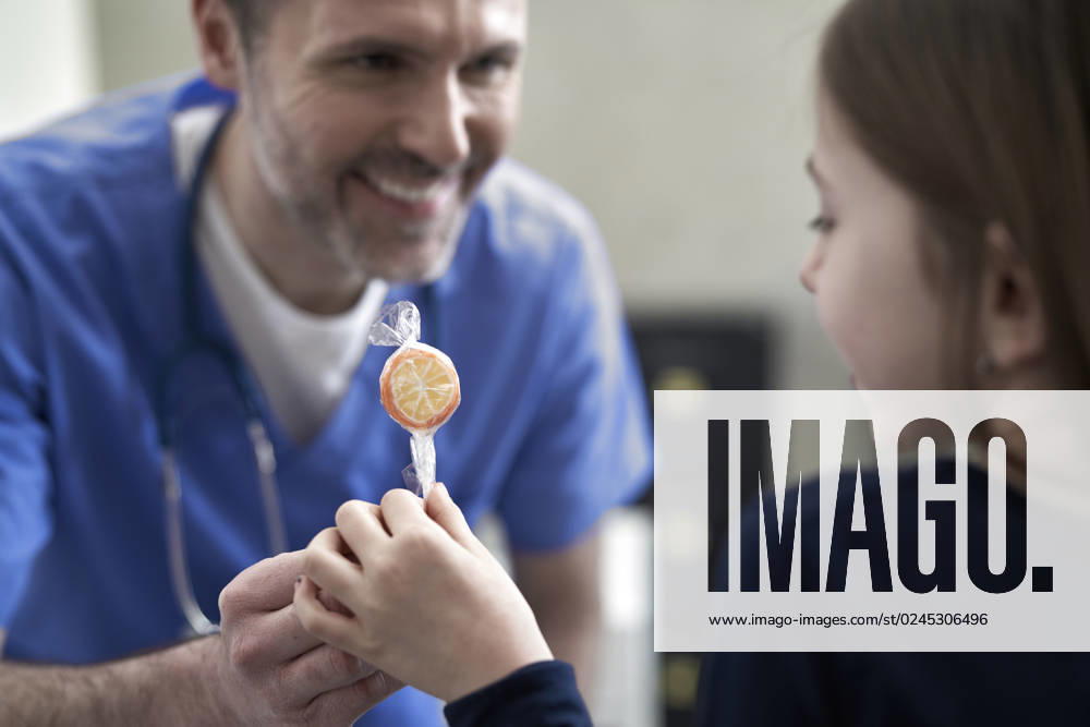 Happy doctor giving lollipop to girl in clinic model released, Symbolfoto property released, ABIF01892