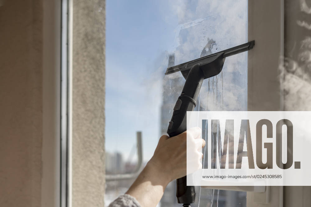 Hand of woman cleaning window with clean steam generator at home model released, Symbolfoto, ANAF01087