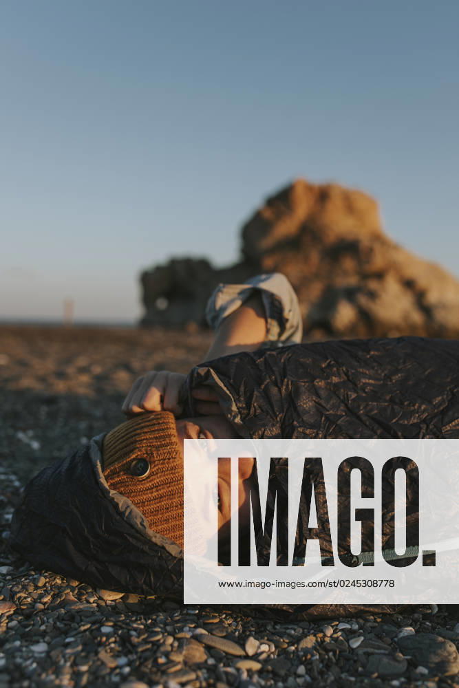 Woman wearing knit hat in sleeping bag at beach model released, Symbolfoto, DMGF01116