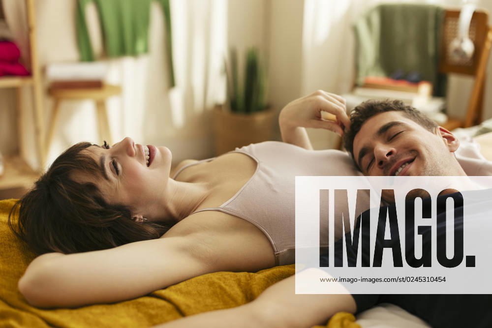 Smiling boyfriend with woman relaxing on bed at home model released, Symbolfoto property released, EBSF02997