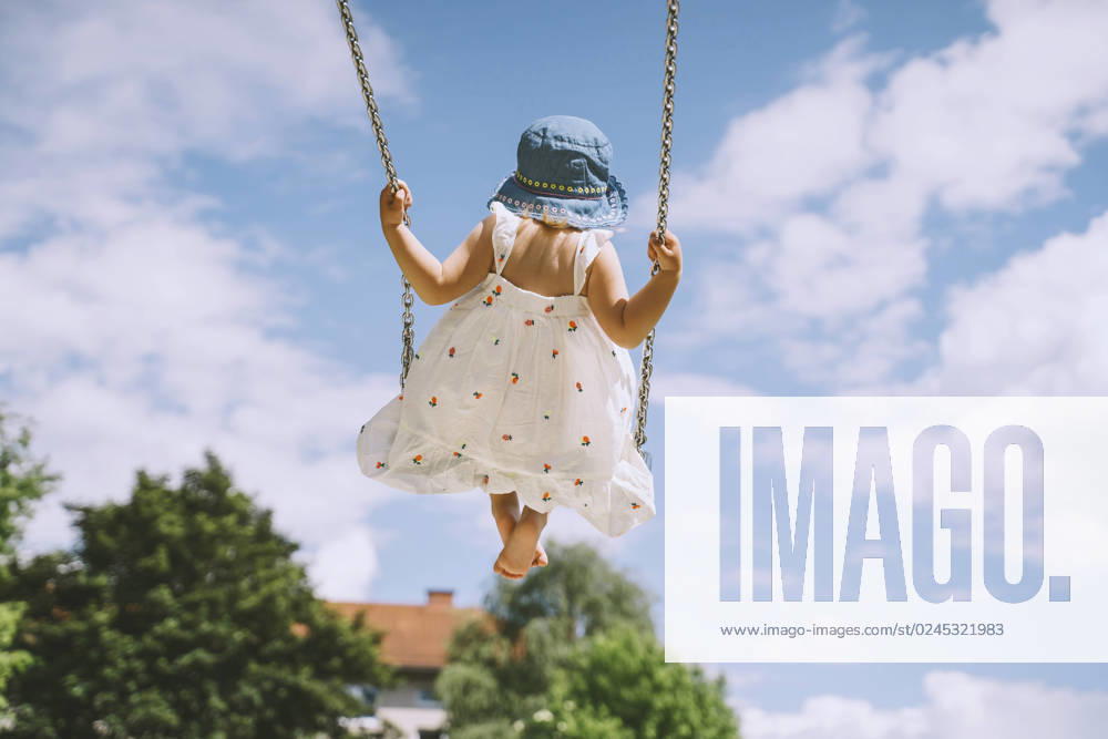 Girl swinging on swing in front of cloudy sky model released, Symbolfoto, NDEF00458