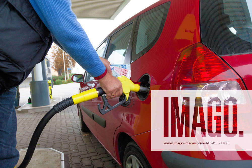 Frau beim tanken auf Tankstelle Eine junge Frau Tankbenzin auf einer Tankstelle. Die Kosten für das Auto werden wegen der Benzinpreise immer teurer
