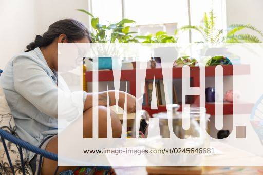 IMAGO Creative, Gesellschaft, Leisure Sickness A Mexican brunette female reading a book and drinking tea *** einer Mexikanische brünett weiblich Lesung einer Buch und trinkend Tee 2795630 ,model released, Symbolfoto ,property released