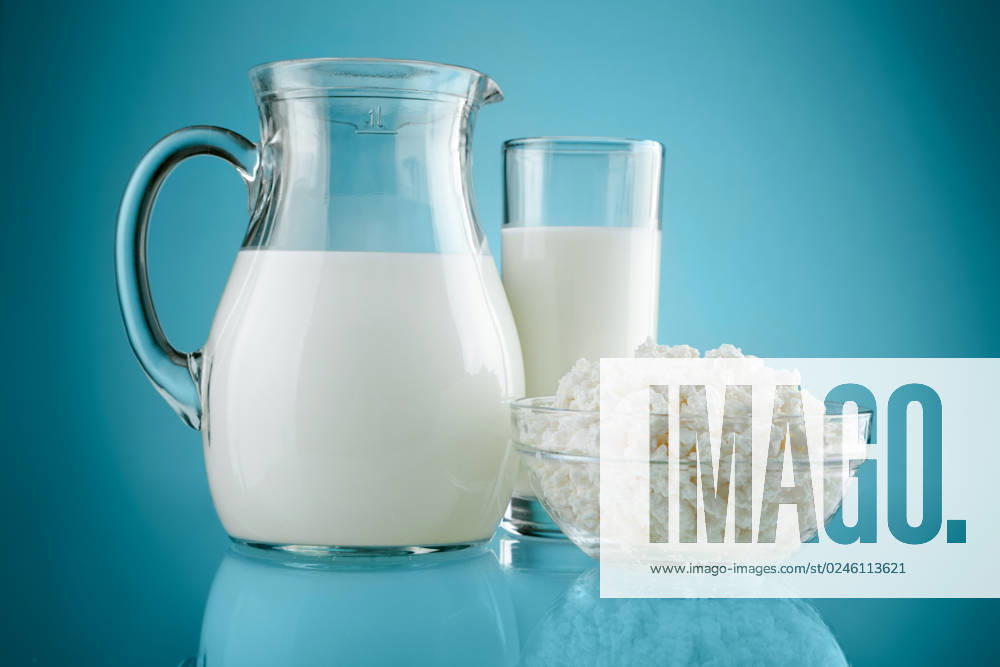 Jug glass with milk and curds on blue background