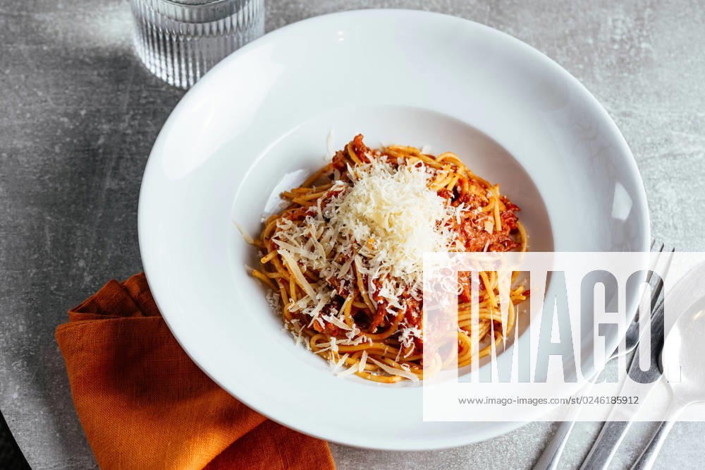 Pasta bolognese in a white plate on a light table in a restauran Washington, District of Columbia, United States R_KUAL230306D-1146753-01