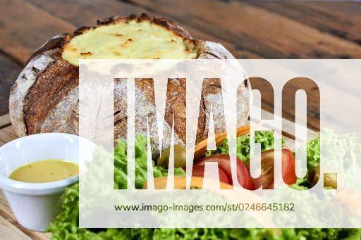 A selective focus shot of peasant bread stuffed with meat covered with cheese and salad on the side *** einer selektive Fokus erschossen des bäuerlicher Brot ausgestopft mit Fleisch Gedeckter mit Käse und Salat am der Bordwand 3788287