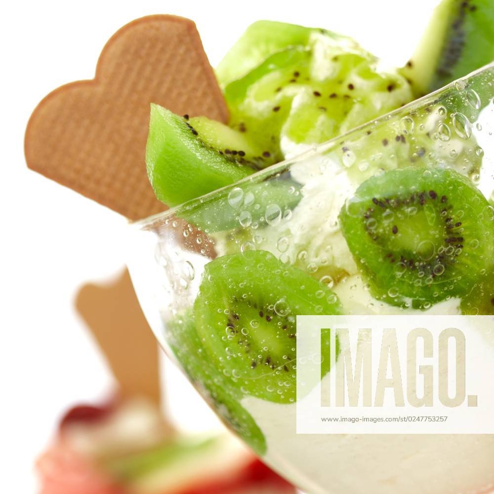 Cup full of kiwi and vanilla ice cream with a waffle