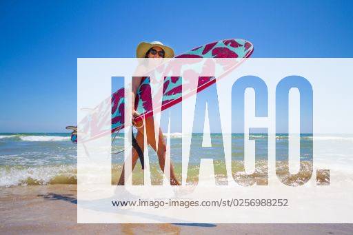 A Hispanic woman wearing swimwear while holding a surfboard on the beach *** einer hispanisch Frau wearing Badekleidung wärend haltend einer Surfbrett am der Strand 6936227 ,model released, Symbolfoto