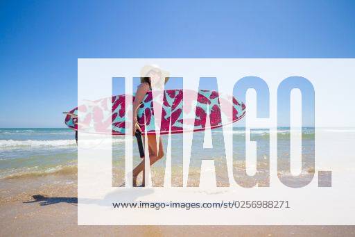 A Hispanic woman wearing swimwear while holding a surfboard on the beach *** einer hispanisch Frau wearing Badekleidung wärend haltend einer Surfbrett am der Strand 6936251 ,model released, Symbolfoto