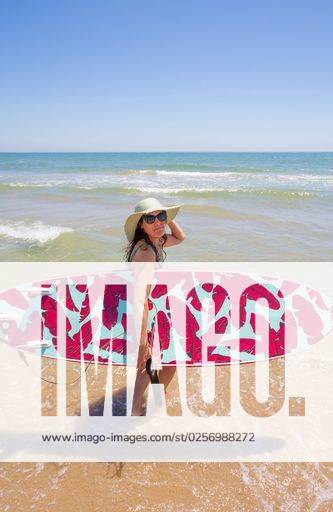 A Hispanic woman wearing swimwear while holding a surfboard on the beach *** einer hispanisch Frau wearing Badekleidung wärend haltend einer Surfbrett am der Strand 6936252 ,model released, Symbolfoto