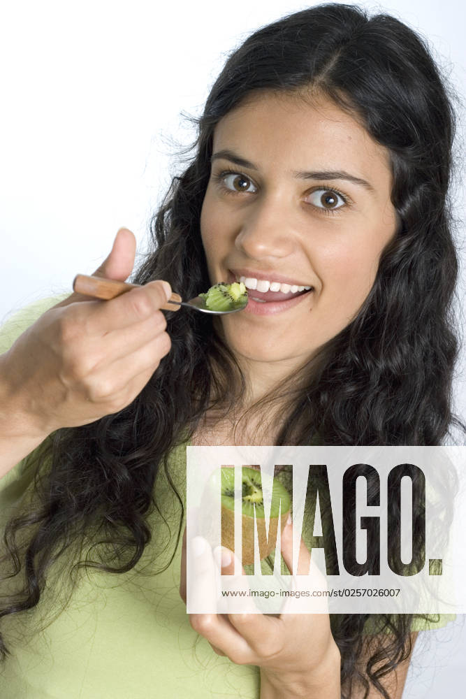 Girl eating fresh kiwi with spoon