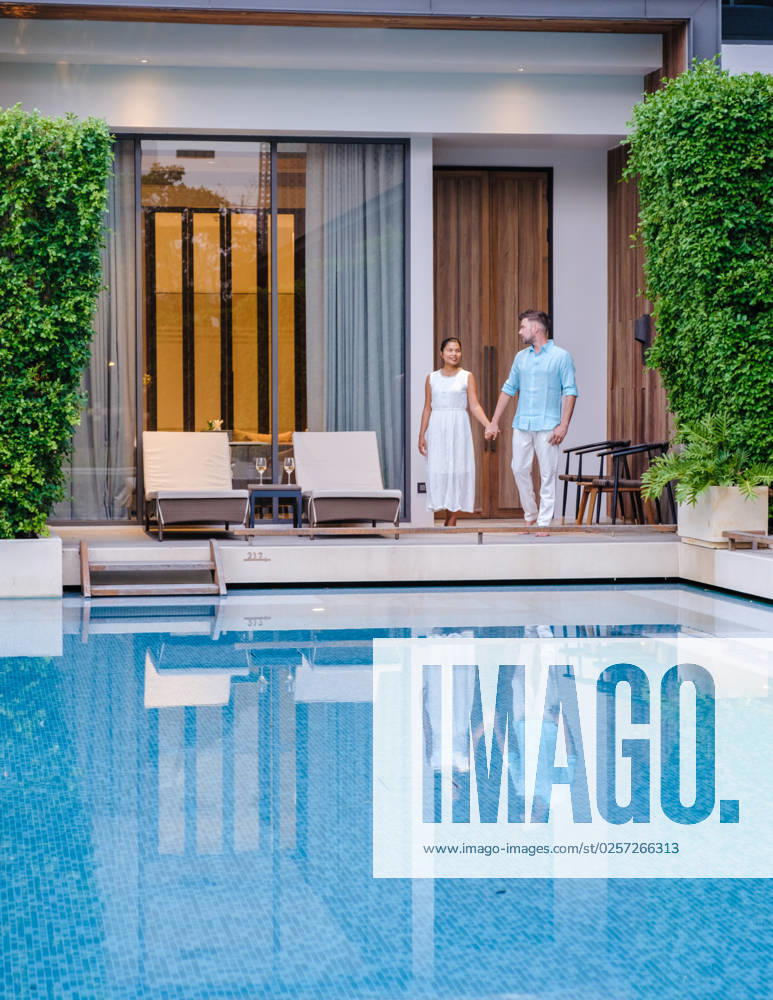 Luxury 5 star hotel pool in Asia A couple of men and women on vacation at a luxury hotel resort, Luxury 5 star hotel pool in Asia. A couple of men and women on vacation at a luxury hotel resort, caucasian men and Thai women by the pool ,model released, Symbolfoto