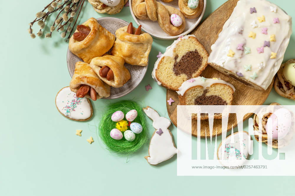 Festive dinner, Easter brunch. Happy Easter holiday food baking puff pastry and cupcake with Easter Bunny on pastel green background. View from above. Copy space. Festive dinner, Easter brunch. Happy Easter holiday food baking puff pastry and cupcake with Easter Bunny on pastel green background. View from above. Copy space.