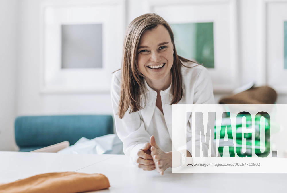 Happy fashion designer leaning on workbench model released, Symbolfoto property released, ADF00025