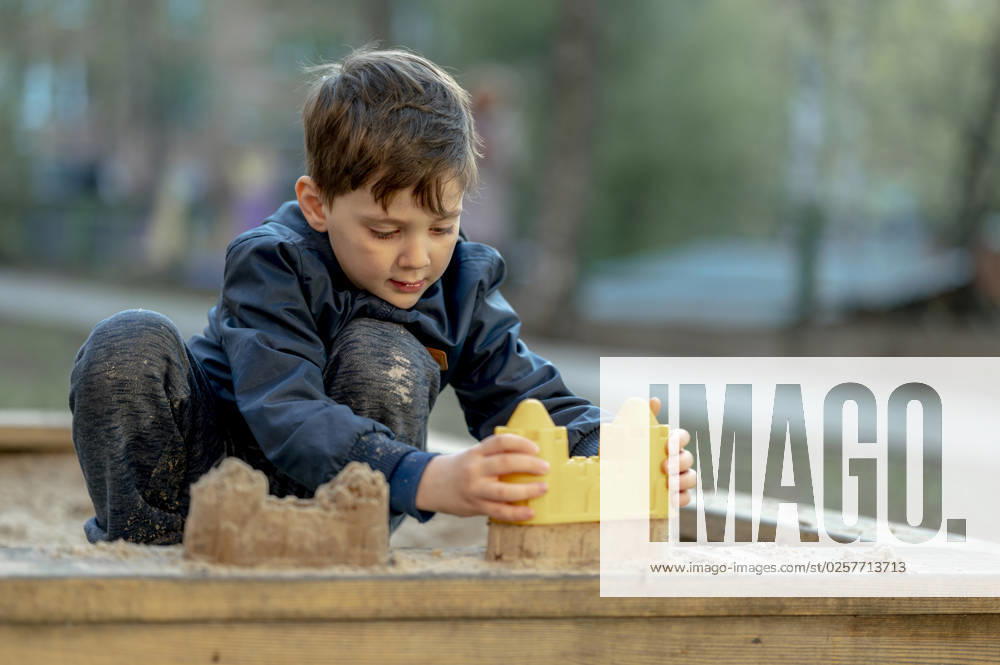 Boy building sandcastle with toy at park model released, Symbolfoto, ANAF01380