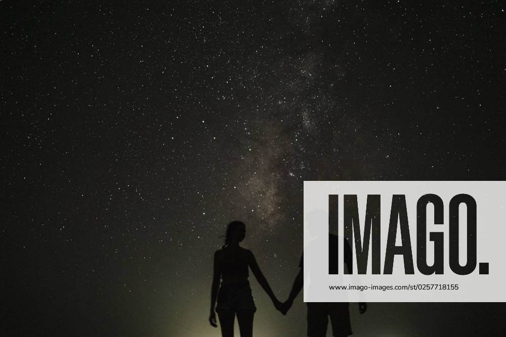 Silhouette of couple holding hands standing at night model released, Symbolfoto, GMLF01453