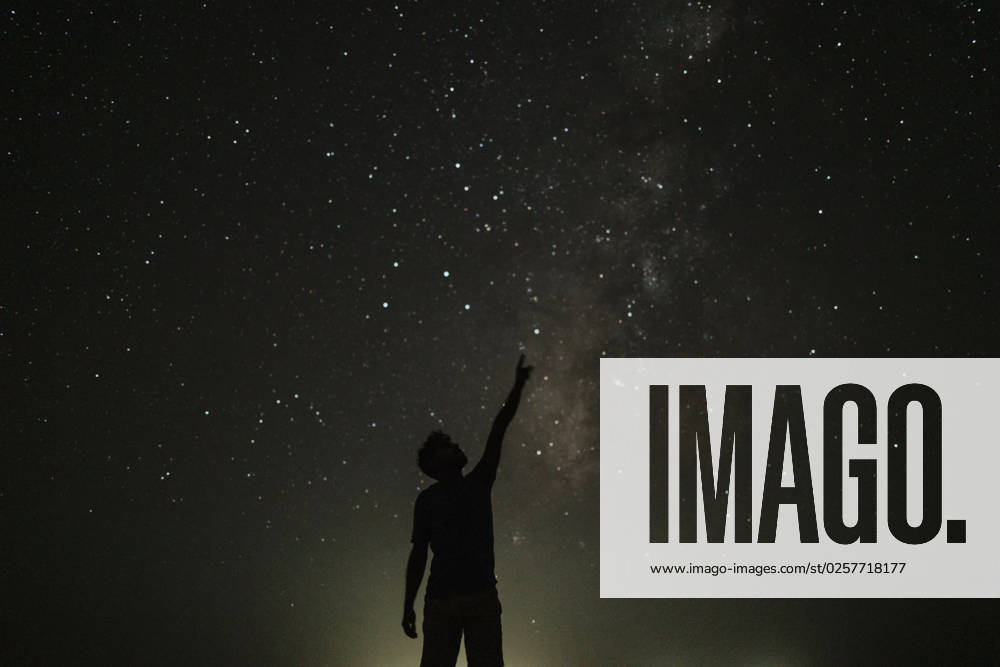 Silhouette of young man pointing towards stars model released, Symbolfoto, GMLF01456