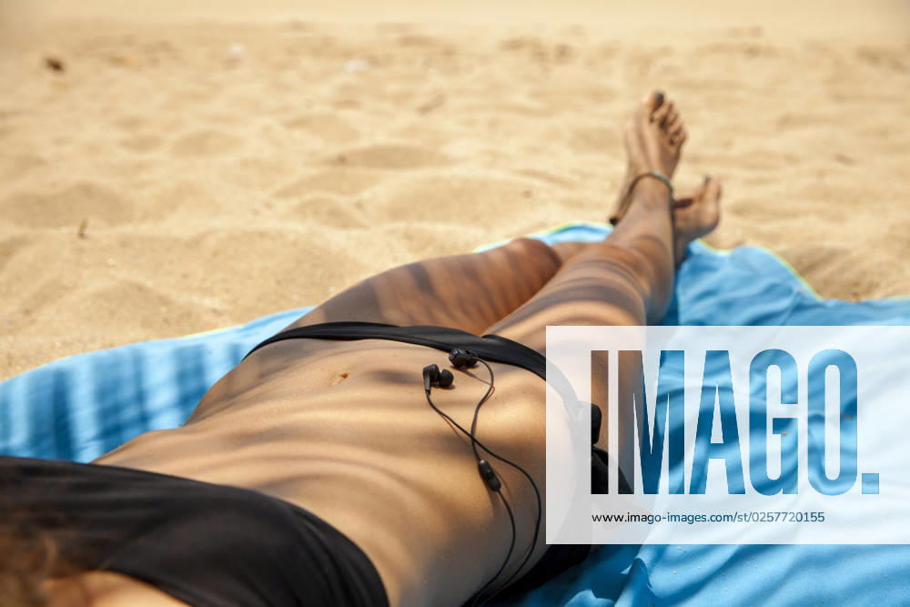 Young woman with headphones relaxing at beach model released, Symbolfoto, IKF00339