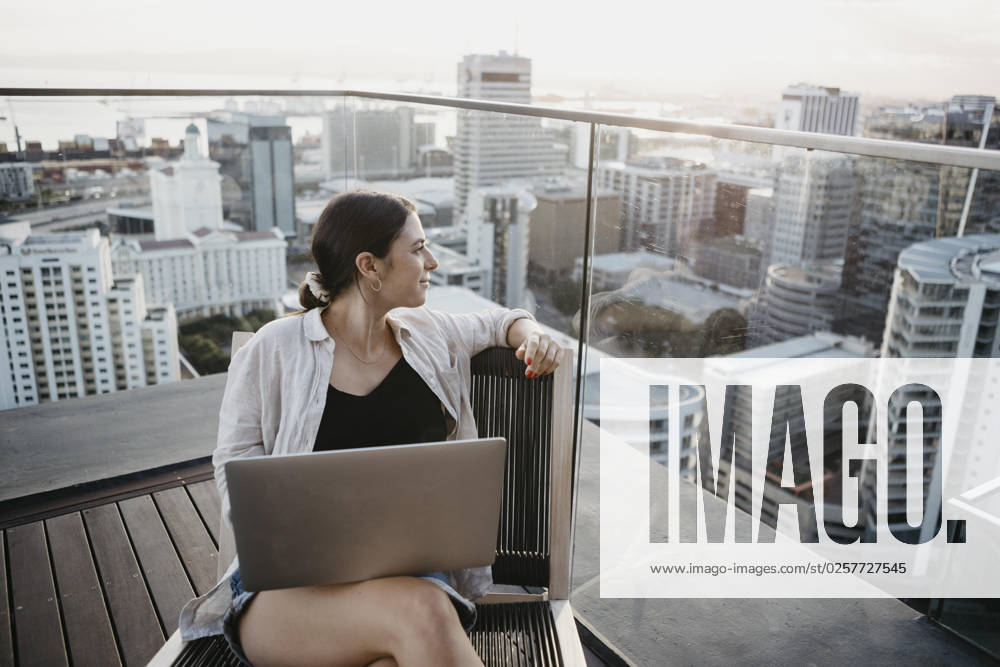 IMAGO Creative, Urban Lifestyle Freelancer with laptop sitting on chair on rooftop model released, Symbolfoto, LHPF01590