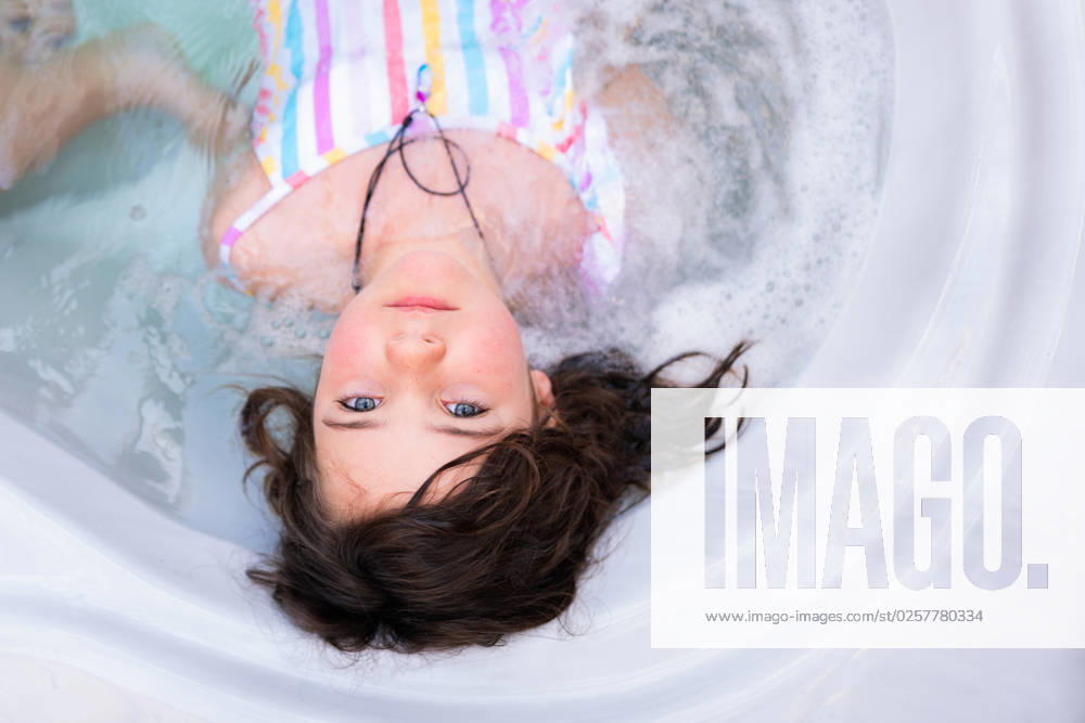 MR_ID14015_13411_ArhaneUnzueta.jpg Top view of relaxed girl in swimwear looking at camera while lying in water of pool in bathtub, Model released HodeiUnzueta_ID14015_422830_002