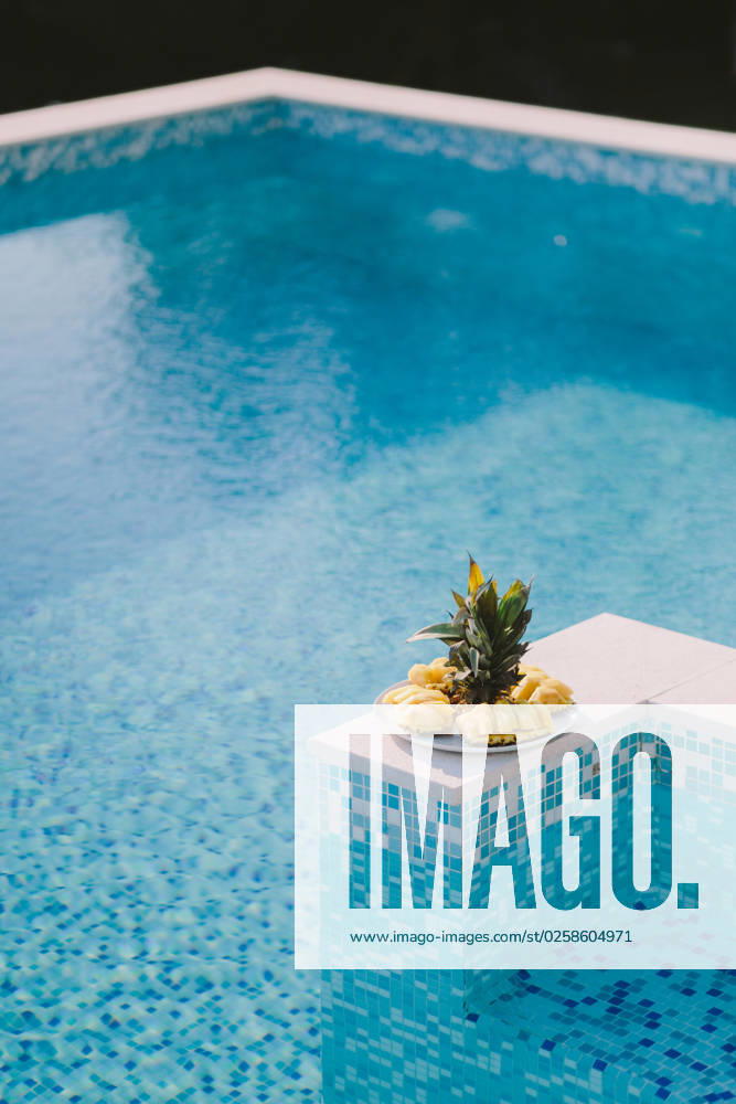 Juicy pineapple sliced juicy pineapple sliced on plate with swimming pool background. summer days ,model released, Symbolfoto