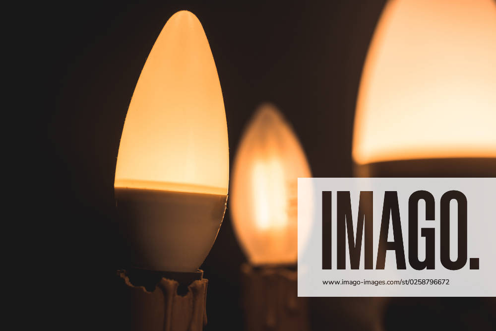 A lamp with light bulbs shines in the night in a dark room