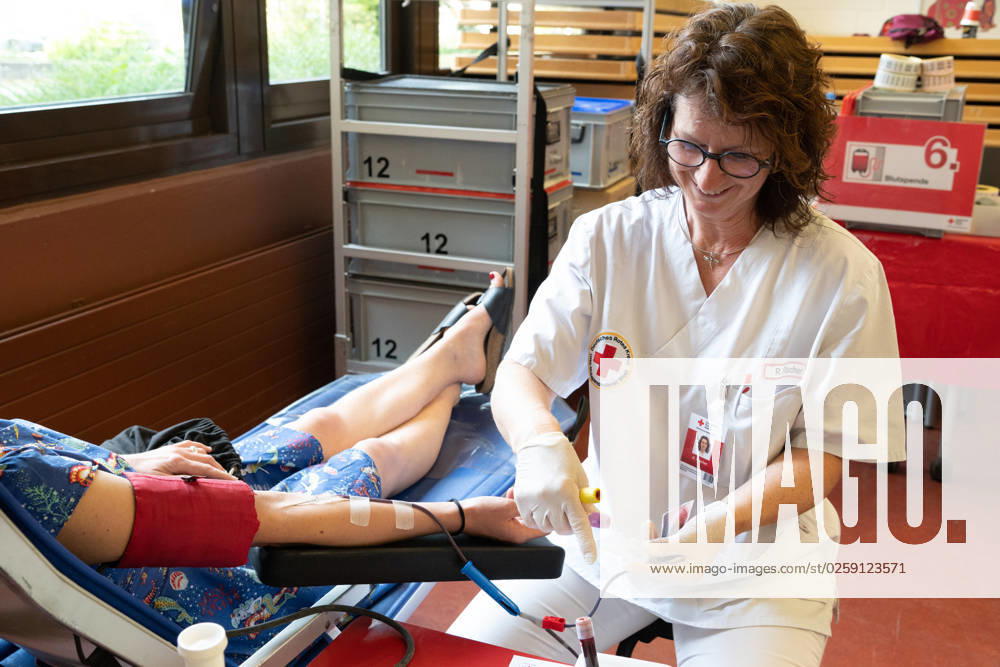 An employee of the DRK blood donation service puts the cannula on the arm of the donor, theme photos BLUTSPENDE on the occasion of the blood donation campaign of the German Red Cross with the action missingtype for the World Blood Donor Day on June 14, 2023, photo session on 05 06 2023 in the school center Pesch in Cologne,