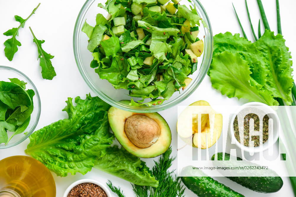 Salad of fresh green vegetables and herbs. Cooking healthy diet or vegetarian food. Step by step recipe. Vegan menu. Fresh spinach and cucumber, arugula avocado. Flax seeds Salad of fresh green vegetables and herbs. Cooking healthy diet or vegetarian food. Step by step recipe. Healthy eating. Ingredients for salad. Raw food concept. A variety of organic fruits and vegetables with avocado. Vegan menu. Fresh spinach and green onion leaves, arugula. Flax seeds