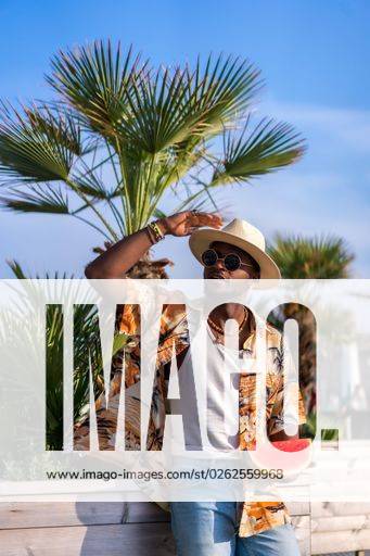 A shallow focus of a young handsome black man eating fresh watermelon at the beach *** einer seicht Fokus des einer Jung gutaussehenden Schwarz Mann essender Frisch Wassermelone im der Strand 19751168 ,model released, Symbolfoto RECORD DATE NOT STATED