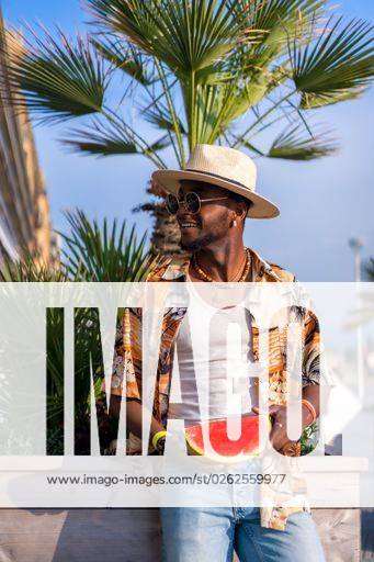 A shallow focus of a young handsome black man eating fresh watermelon at the beach *** einer seicht Fokus des einer Jung gutaussehenden Schwarz Mann essender Frisch Wassermelone im der Strand 19751178 ,model released, Symbolfoto RECORD DATE NOT STATED