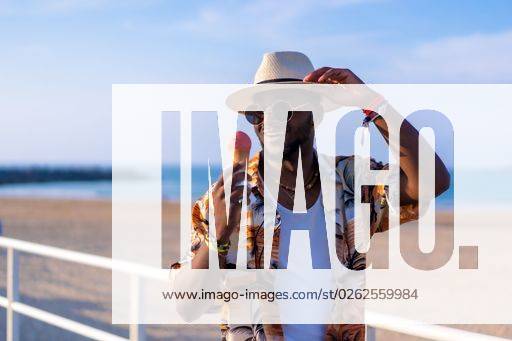 A shallow focus of a young handsome black man eating an ice cream cone at the beach *** einer seicht Fokus des einer Jung gutaussehenden Schwarz Mann essender An&Verkauf Eis Creme Kegel im der Strand 19751186 ,model released, Symbolfoto RECORD DATE NOT STATED