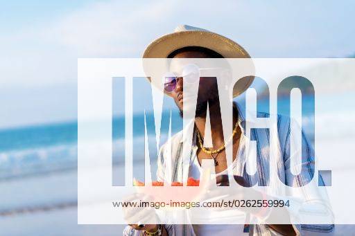 A shallow focus of a young handsome black man eating fresh watermelon at the beach *** einer seicht Fokus des einer Jung gutaussehenden Schwarz Mann essender Frisch Wassermelone im der Strand 19751272 ,model released, Symbolfoto RECORD DATE NOT STATED