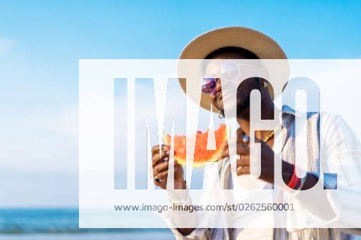 A shallow focus of a young handsome black man eating fresh watermelon at the beach *** einer seicht Fokus des einer Jung gutaussehenden Schwarz Mann essender Frisch Wassermelone im der Strand 19751282 ,model released, Symbolfoto RECORD DATE NOT STATED
