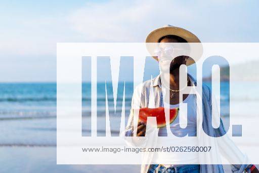 A shallow focus of a young handsome black man eating fresh watermelon at the beach *** einer seicht Fokus des einer Jung gutaussehenden Schwarz Mann essender Frisch Wassermelone im der Strand 19751290 ,model released, Symbolfoto RECORD DATE NOT STATED