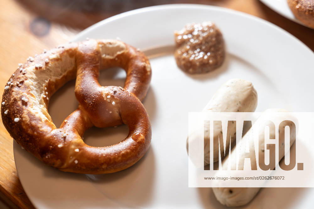 Augsburg, Bavaria, Germany - 2 July 2023: Bavarian vegan white sausage on a table for breakfast with pretzel and sweet mustard