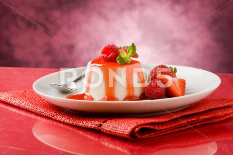 Photo of italian panna cotta dessert with strawberry sirup and mint leaf panna cotta,yogurt,yoghurt,yoghurt sauce,berries,strawberry,raspberry,mint,cheese,milk,gelatin,pudding,cream,creamy,cake,sweet,desseert,good,tasty,berry,leaf,leaves,glass table,healthy food,italian cuisine,italian food,sirup