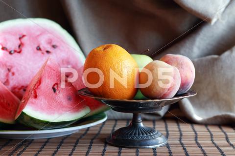 Still life with various fruits in metal bowl near sliced watermelon Fruit, Berry, Watermelon, Food, Summer, Plant, Healthy Eating, Dessert, Background, Macro, Closeup, Red, Slice, Cut, Portion, Plate, Table, Dishware, Morning, Breakfast, Bowl, Still Life, Bowl, Peach, Apple, Orange, Canvas, Decoration, Interior, Vintage, Retro